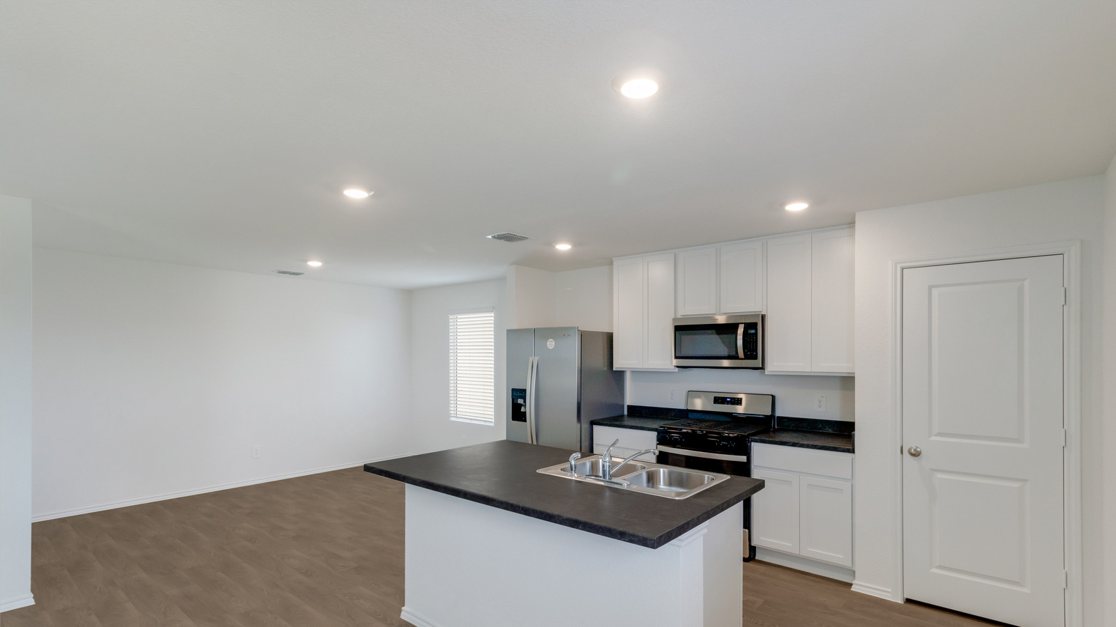 Kitchen featuring cabinets, new stainless steel appliances, and large countertops connecting to dining area.