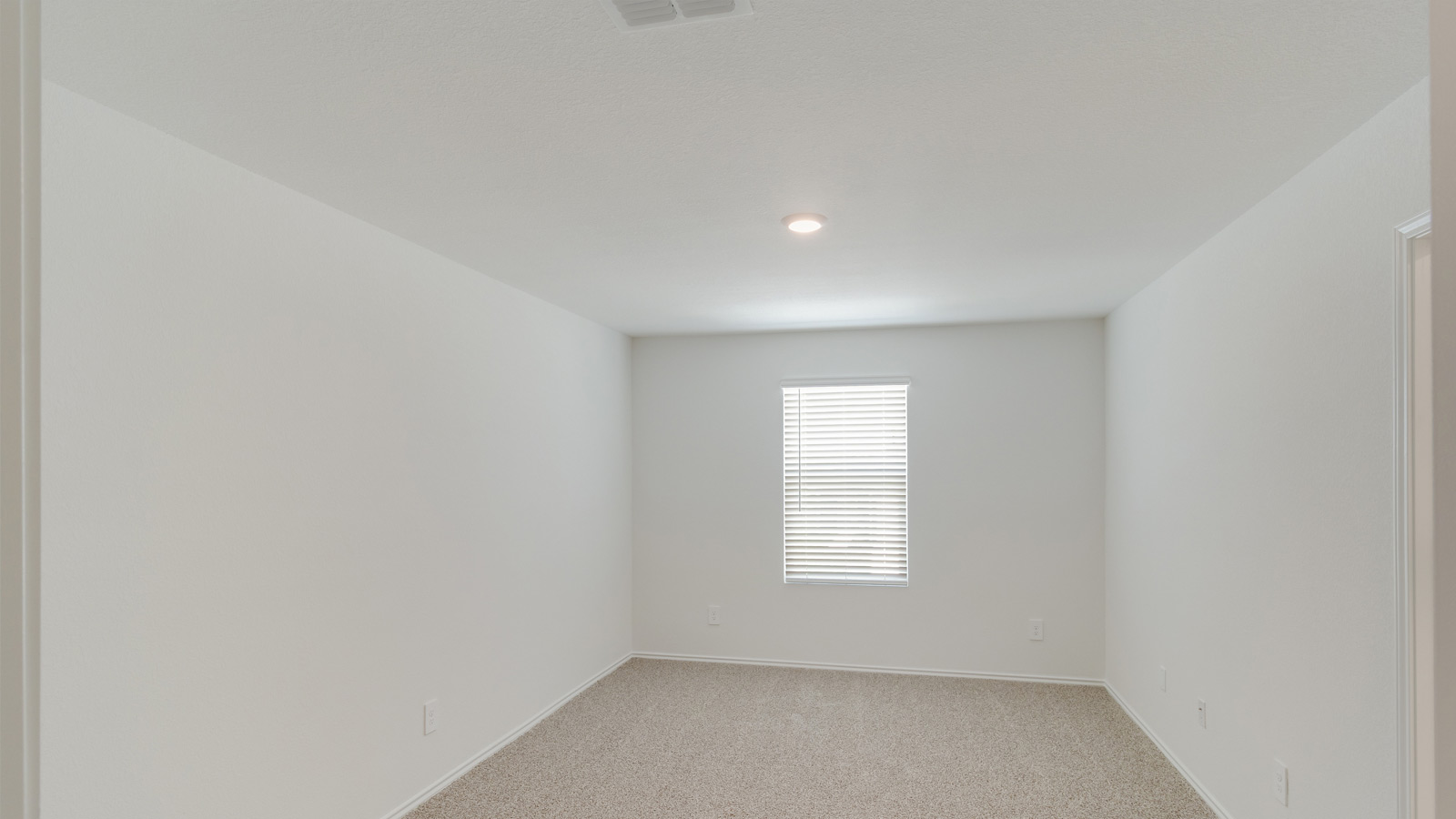 Primary bedroom with large windows and neutral walls.