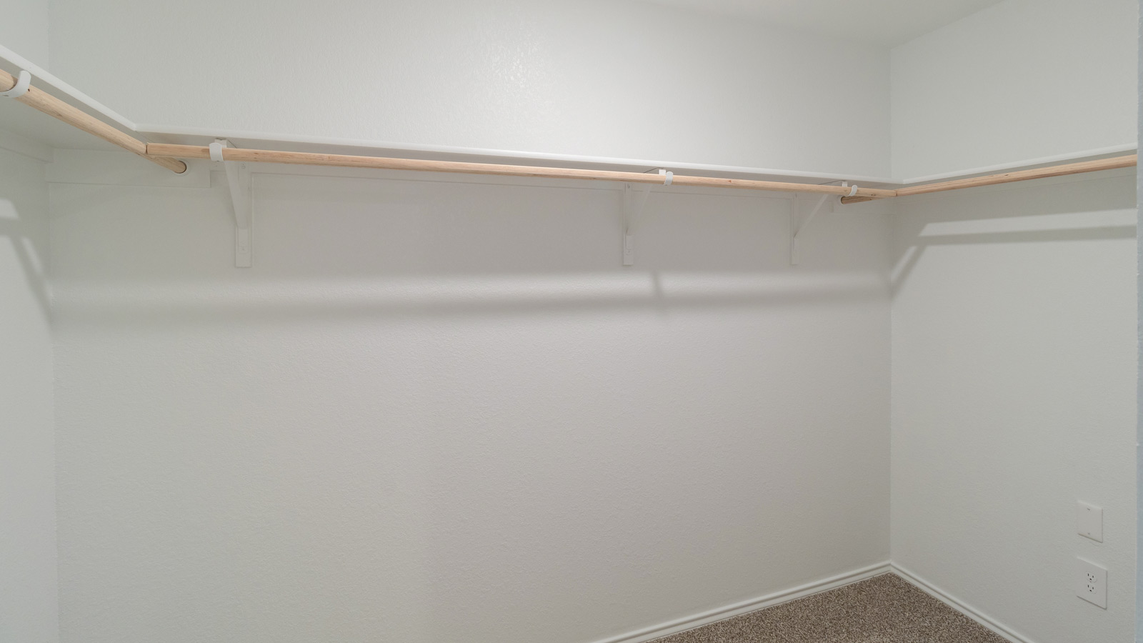 Primary suite walk-in closet in Prairie Lakes new home with built-in shelving and generous storage space