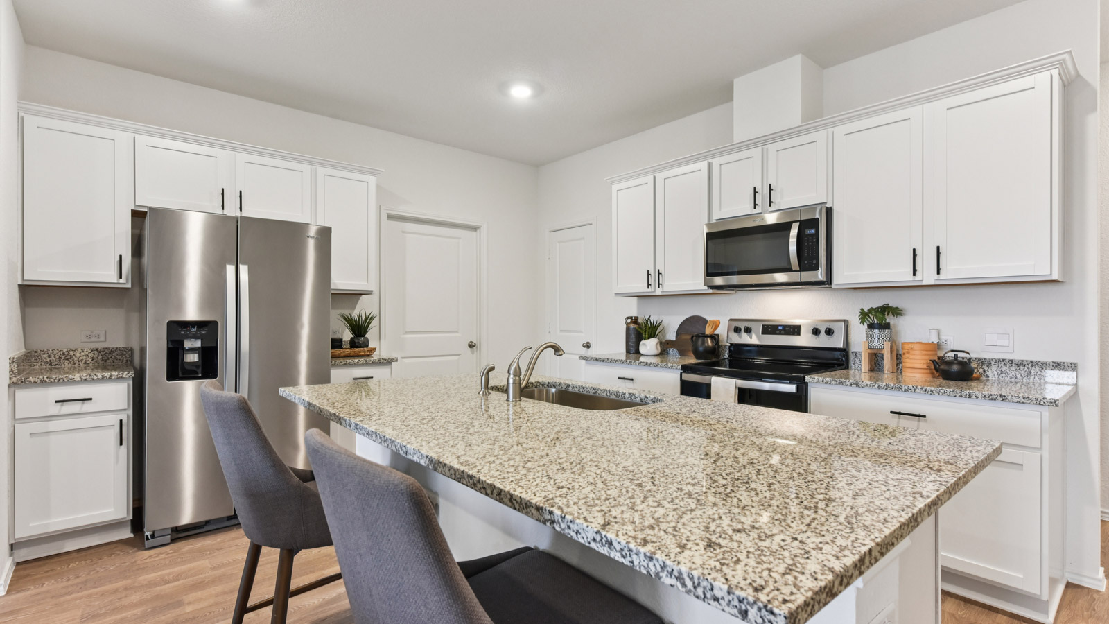 Kitchen with granite countertops and 36" upper cabinets with hardware.