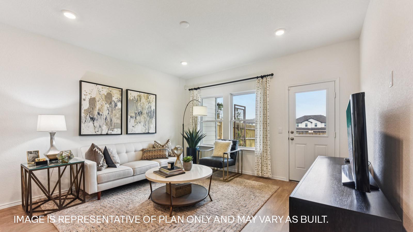 Open living area with vinyl flooring and windows overlooking backyard.