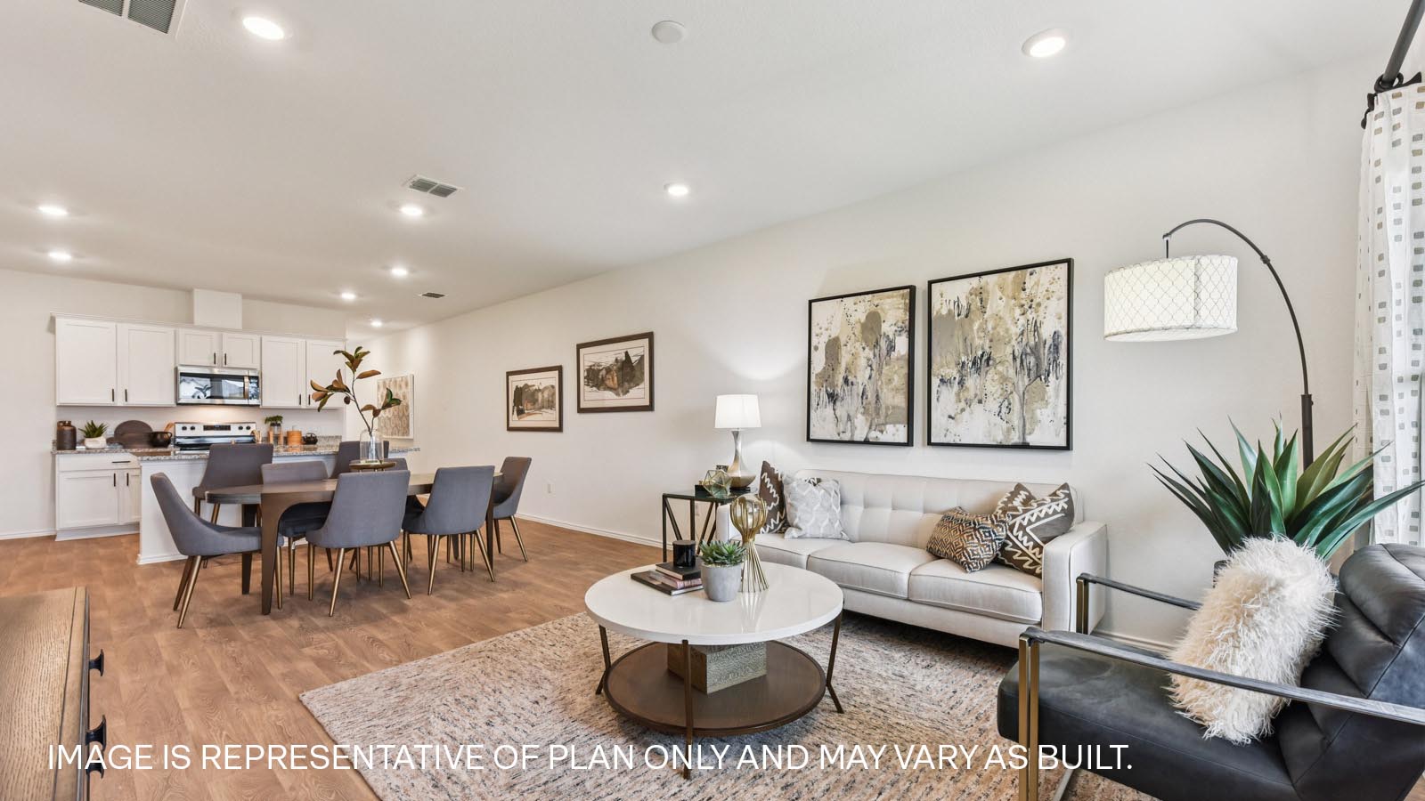 Open living area with vinyl flooring and windows overlooking backyard.