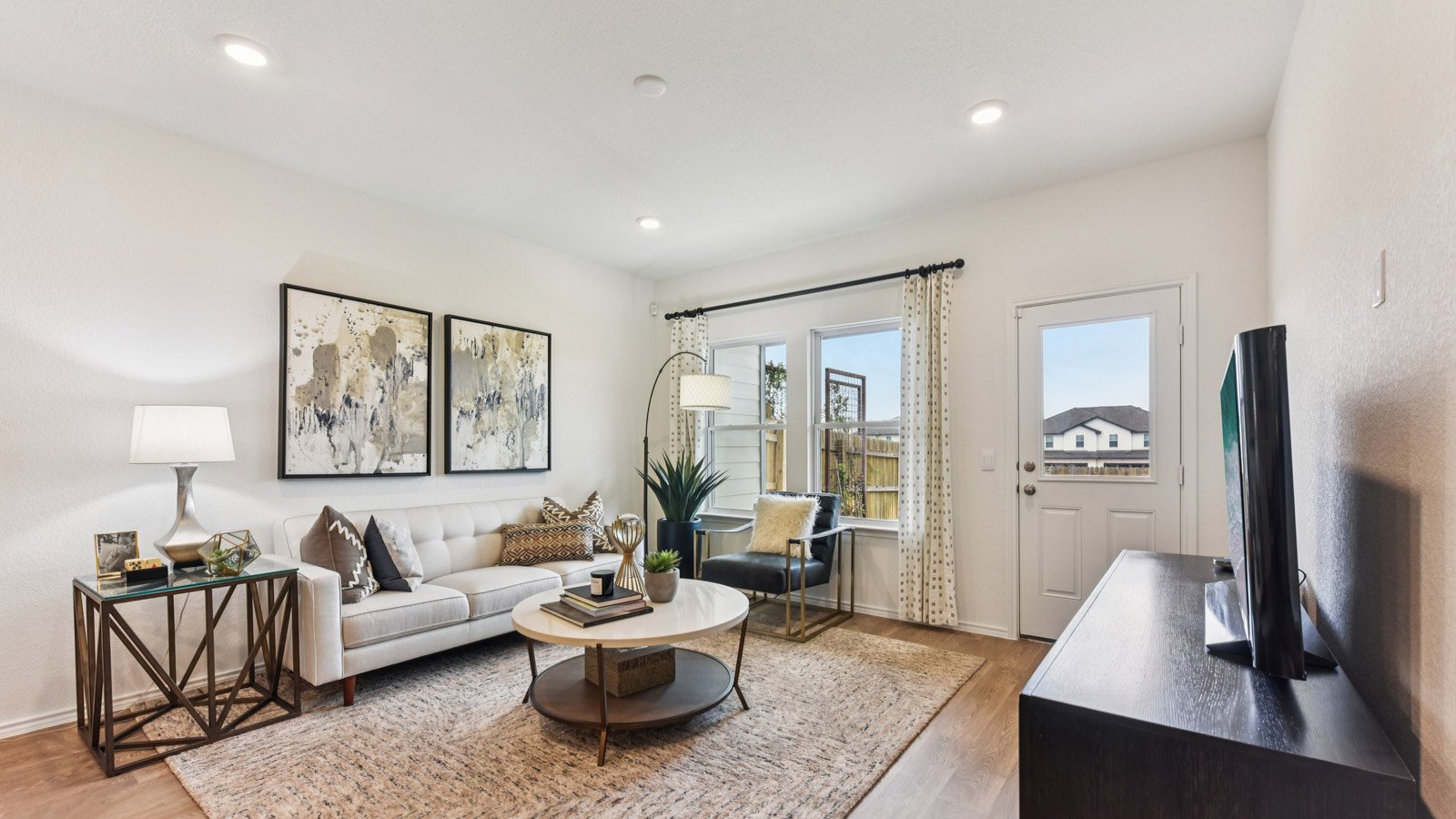 Open living area with vinyl flooring and windows overlooking backyard.