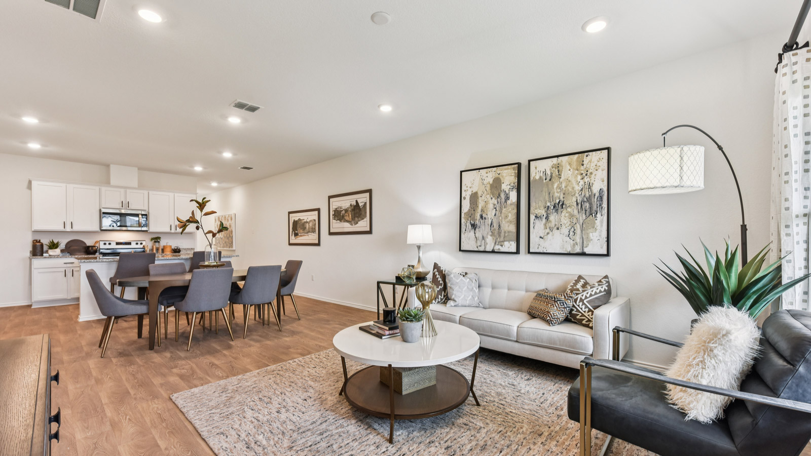 Open living area with vinyl flooring and windows overlooking backyard.
