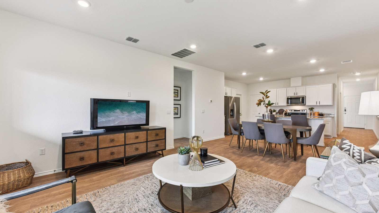 Open living area with vinyl flooring and windows overlooking backyard.