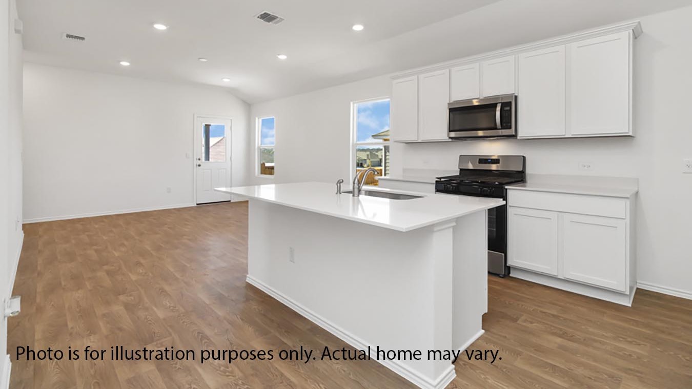 Kitchen with white cabinets, island, white quartz countertop, and stainless steel appliances