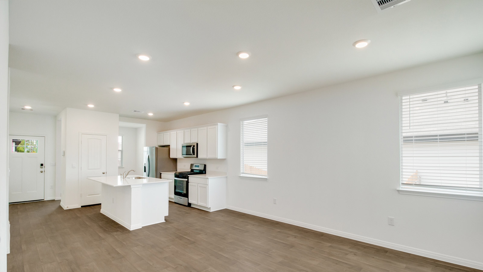Kitchen island in D.R. Horton layout connects dining, main living areas, and outside with efficient flow and modern designs