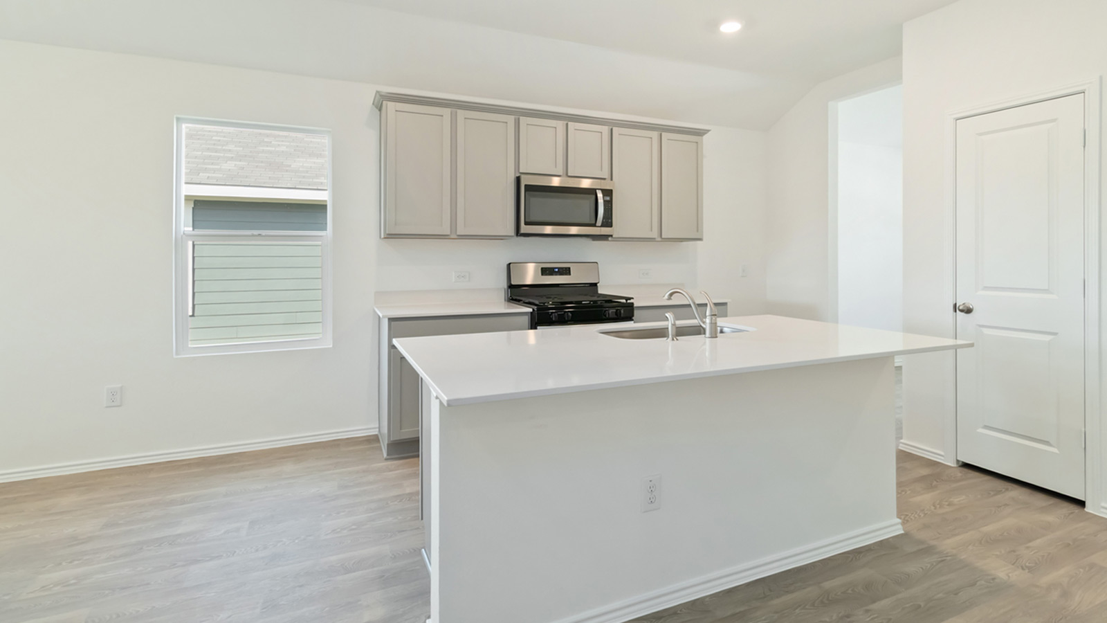 Kitchen with stainless steel appliances and quartz countertops.