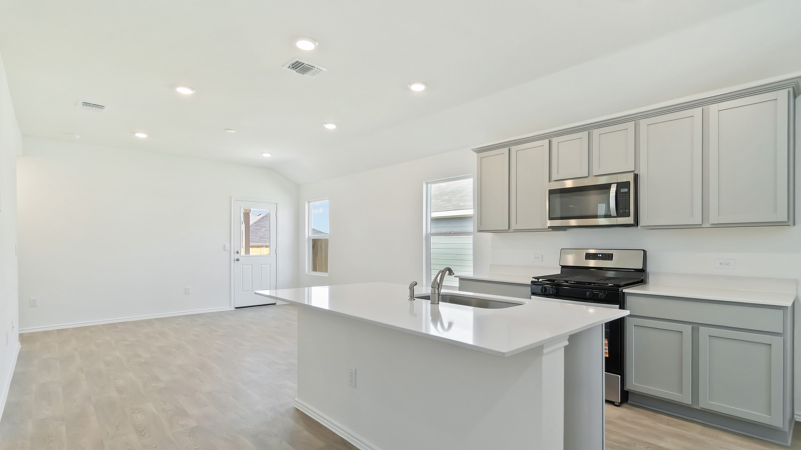 Kitchen with stainless steel appliances and quartz countertops.