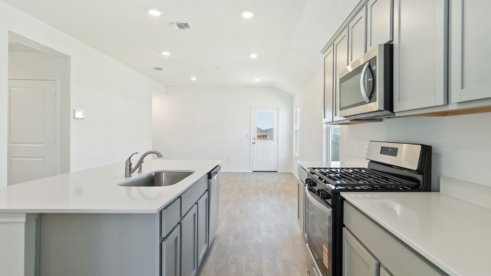 Kitchen with stainless steel appliances and quartz countertops.