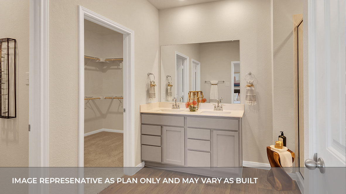 Interior primary bathroom with double sink and walk-in closet