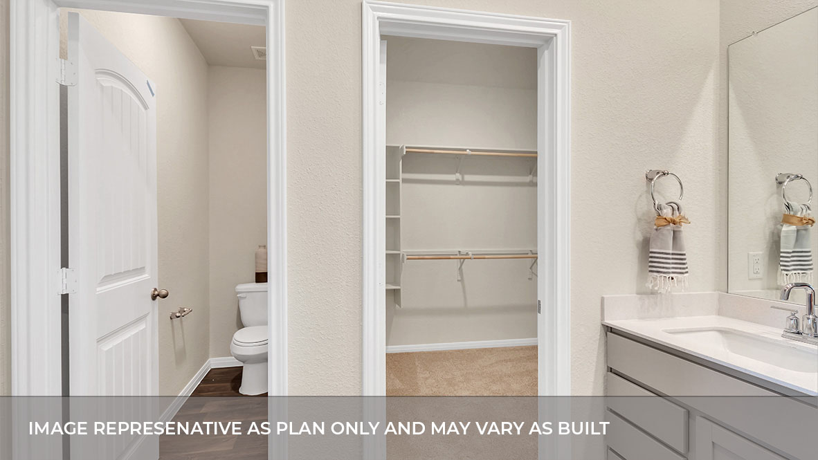 Interior primary bathroom with double sink and walk-in closet