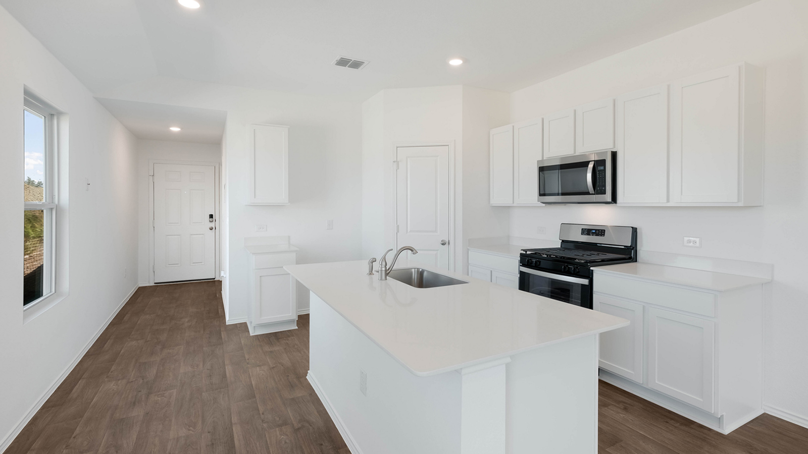 Kitchen with quartz countertops and stainless steel appliances.
