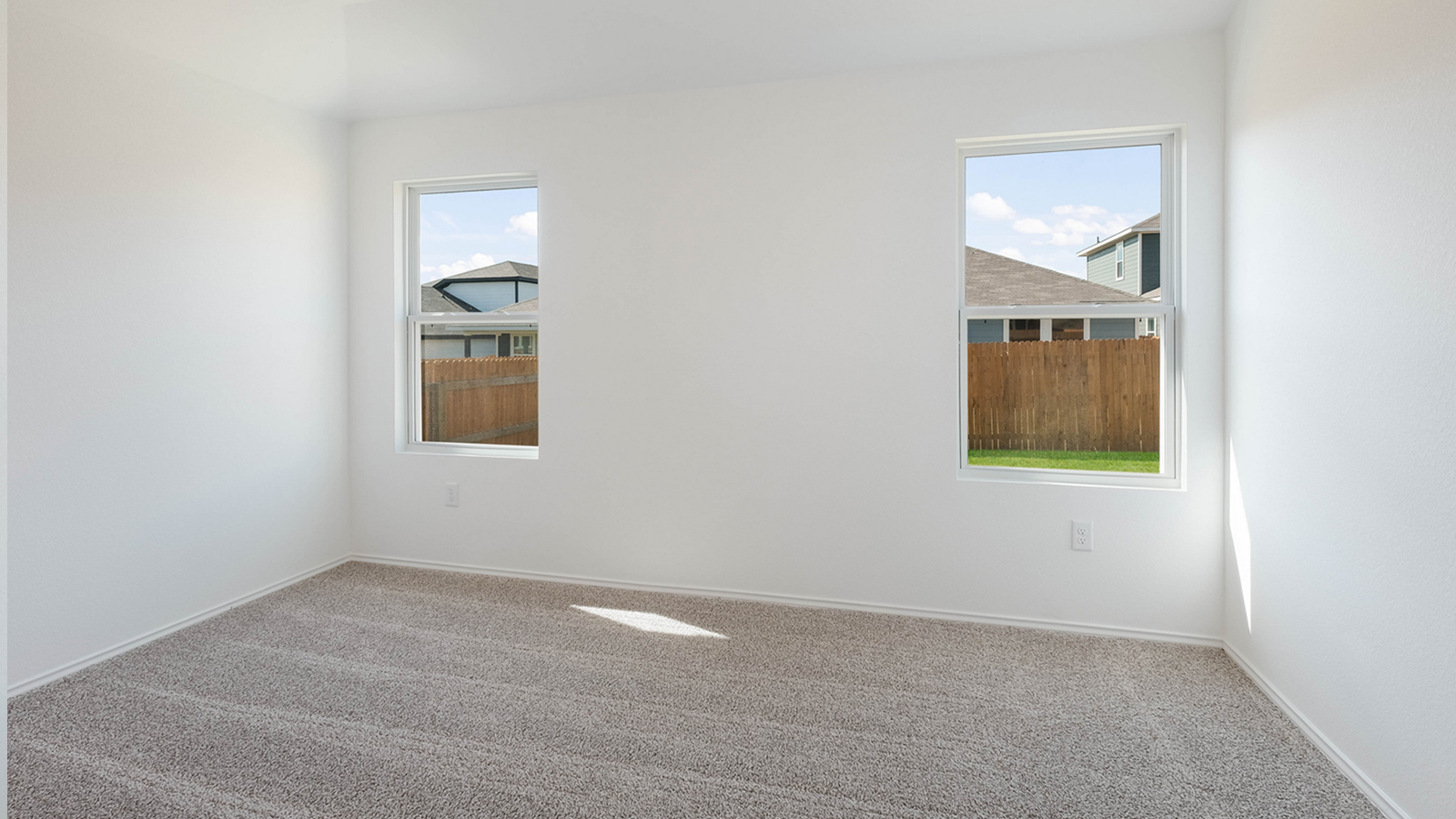 Main bedroom, bedroom 1, with carpeted floors and two windows.