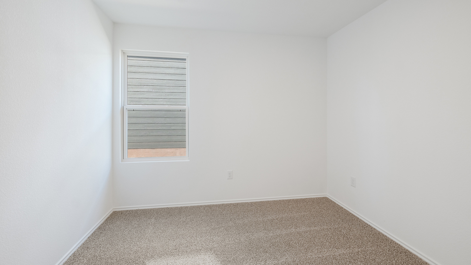 Bedroom 2 with carpeted floors and window.