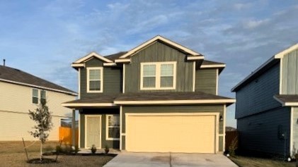 Front exterior Florence floor plan with 2-car garage green siding and shingle roof