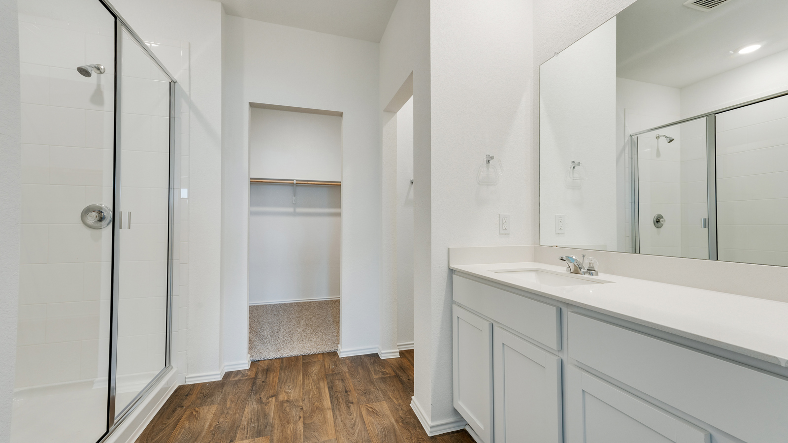Bathroom with walk-in shower and single vanity sink.