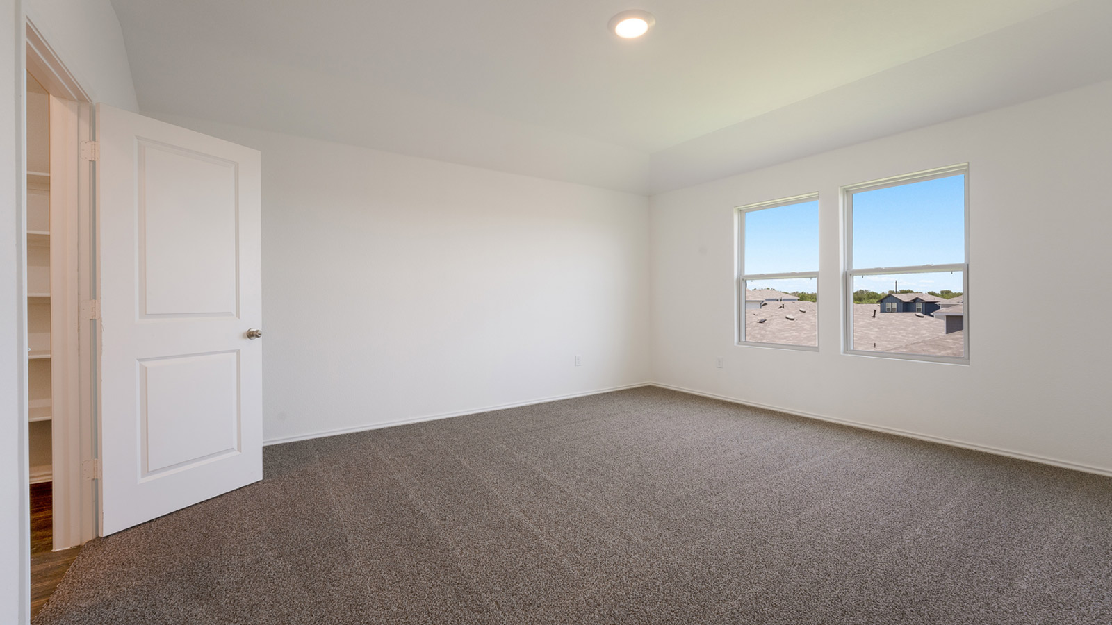 Spacious  main bedroom with carpeted floors. .