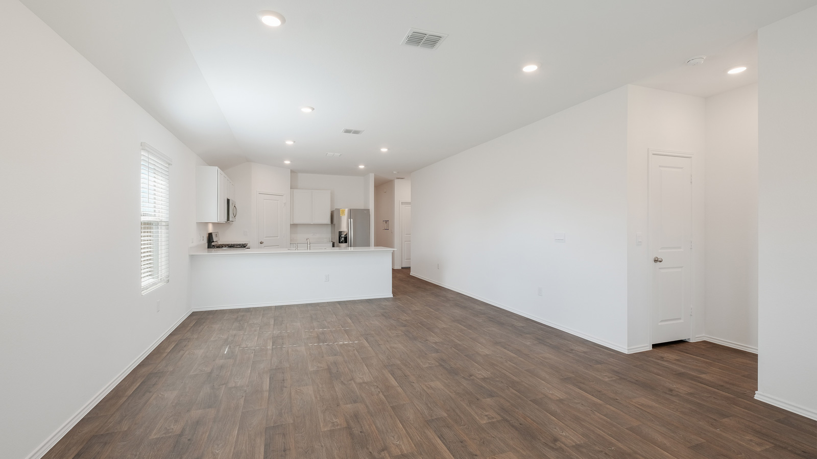 Living room and kitchen with plenty of natural light from windows.