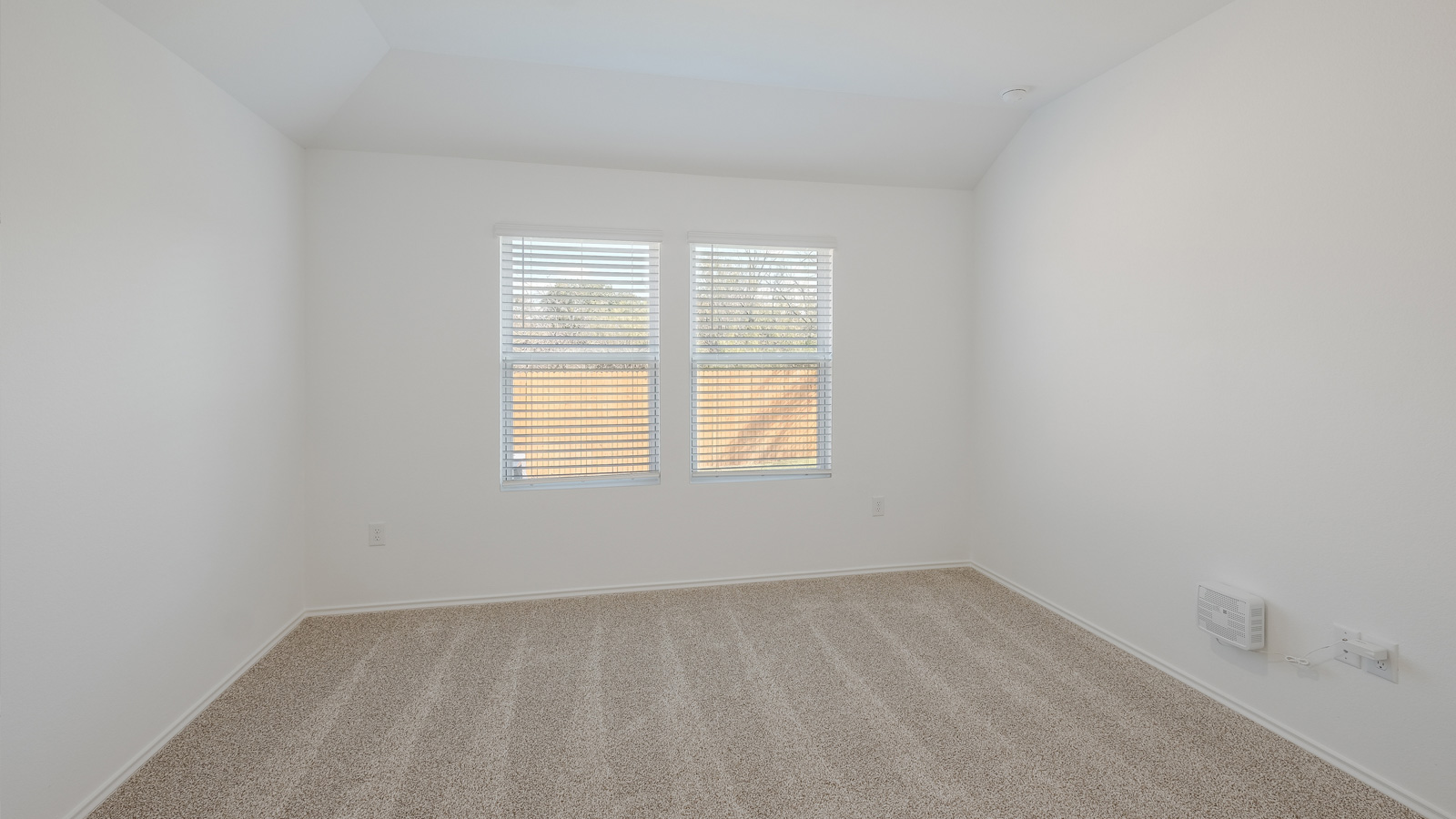 Bedroom 1 with carpeted floors and large window.