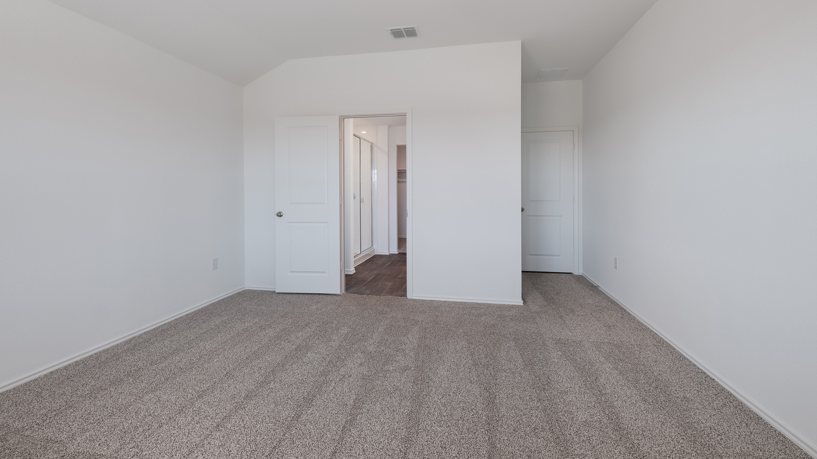 Bedroom 1 with carpeted floors and adjoined bathroom.