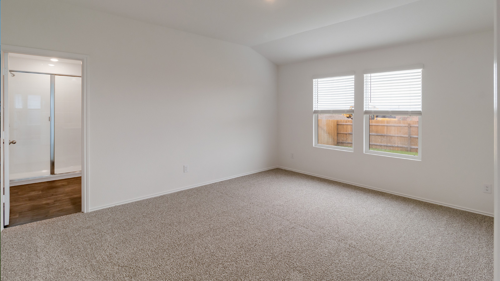 The main bedroom, bedroom 1, with carpeted flooring.