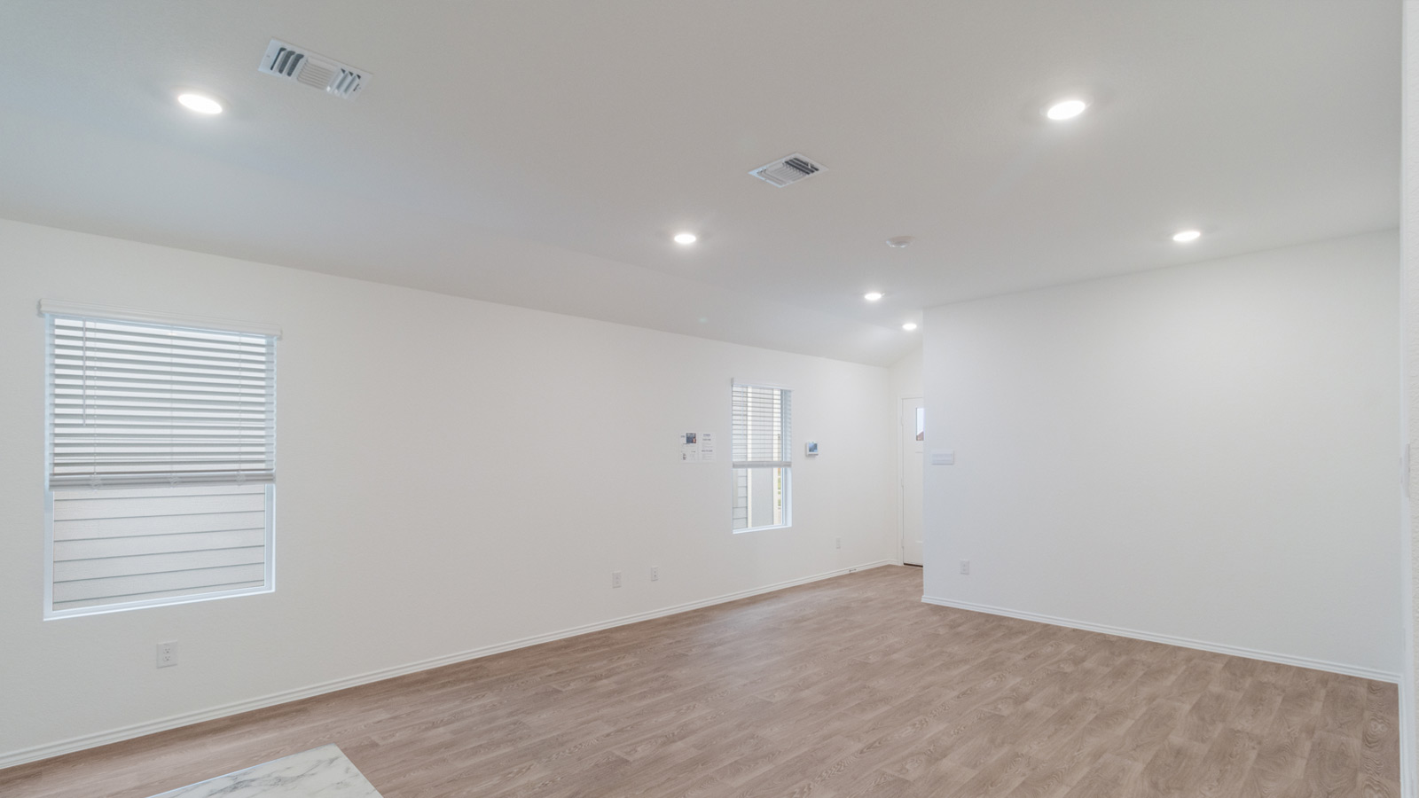 Open living area with laminated wood flooring.
