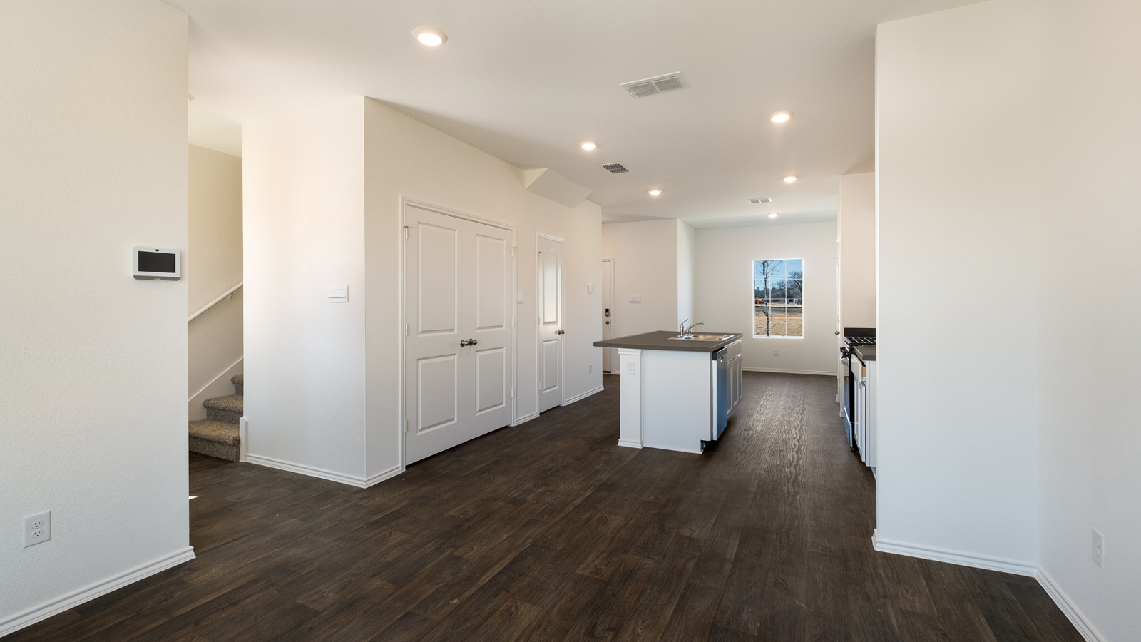 Kitchen island in this new home shares seamless imagination with a sink, dining,living areas and an open concept floor plan