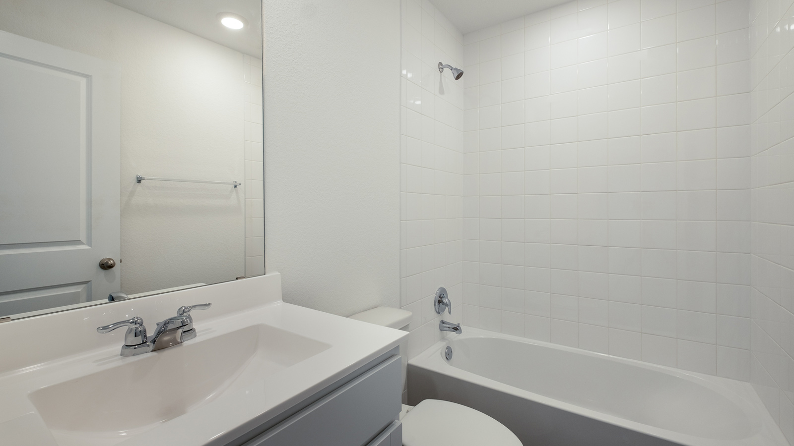 Family bathroom with stylish vanity, mirror, polished fixtures, cabinets, tub-shower combo in Southgrove
