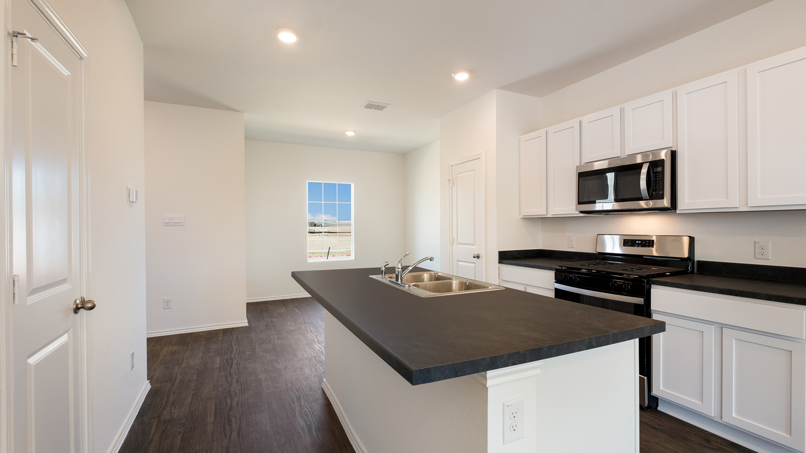 Kitchen island in this new home shares seamless imagination with a sink, dining,living areas and an open concept floor plan