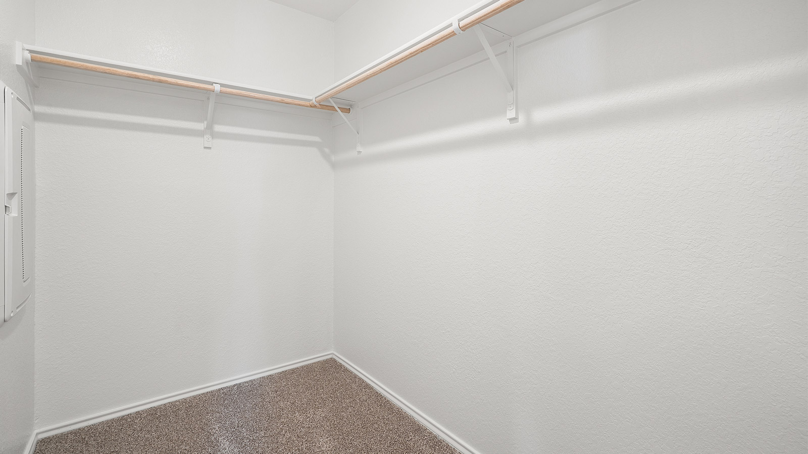 Interior of walk in closet with built in shelving