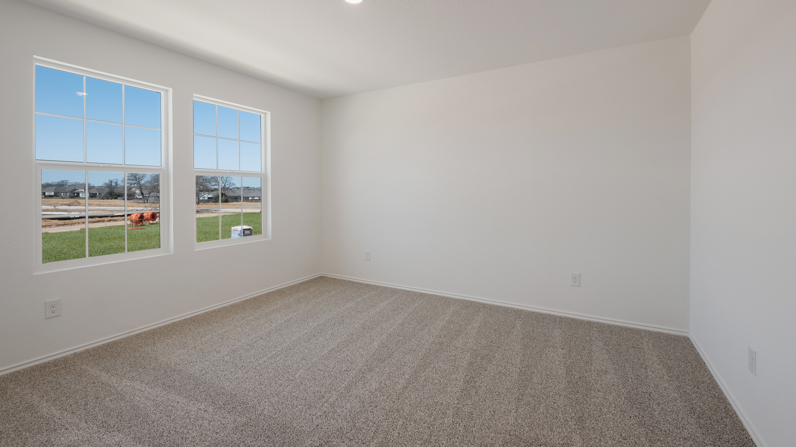 bedroom with beige carpet, white walls and a window