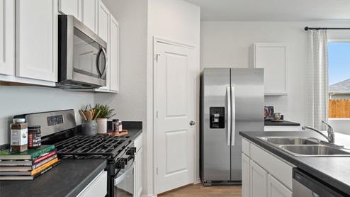 Interior of kitchen with white cabinets and central island