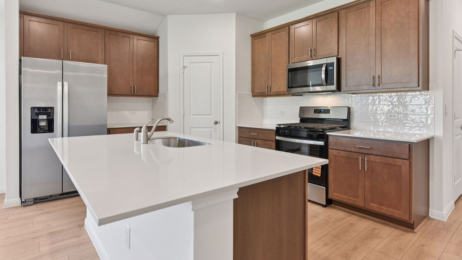 Modern kitchen with quartz countertops, tile backsplash, and 42 inch upper kitchen cabinets.