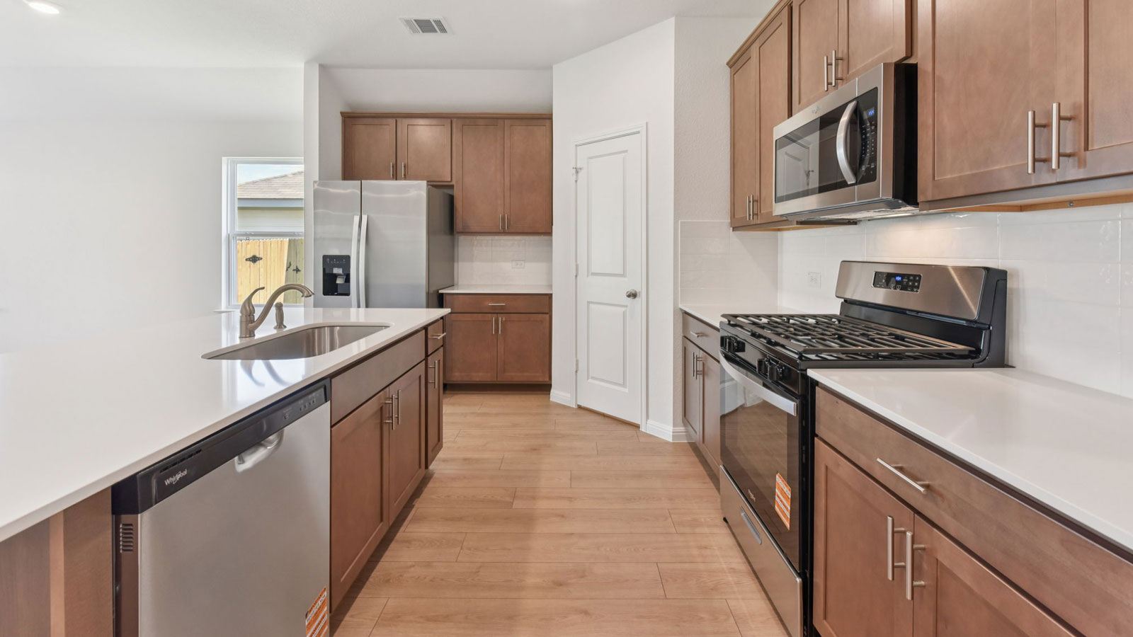 Modern kitchen with quartz countertops, tile backsplash, and 42 inch upper kitchen cabinets.