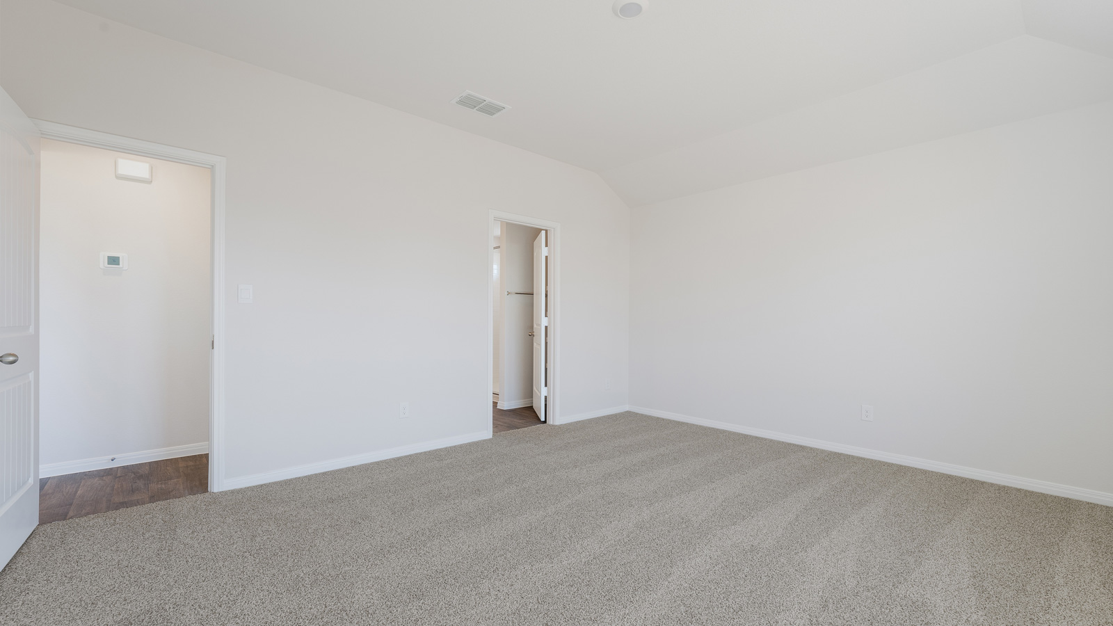 Bedroom 1 with carpeted flooring and large window.
