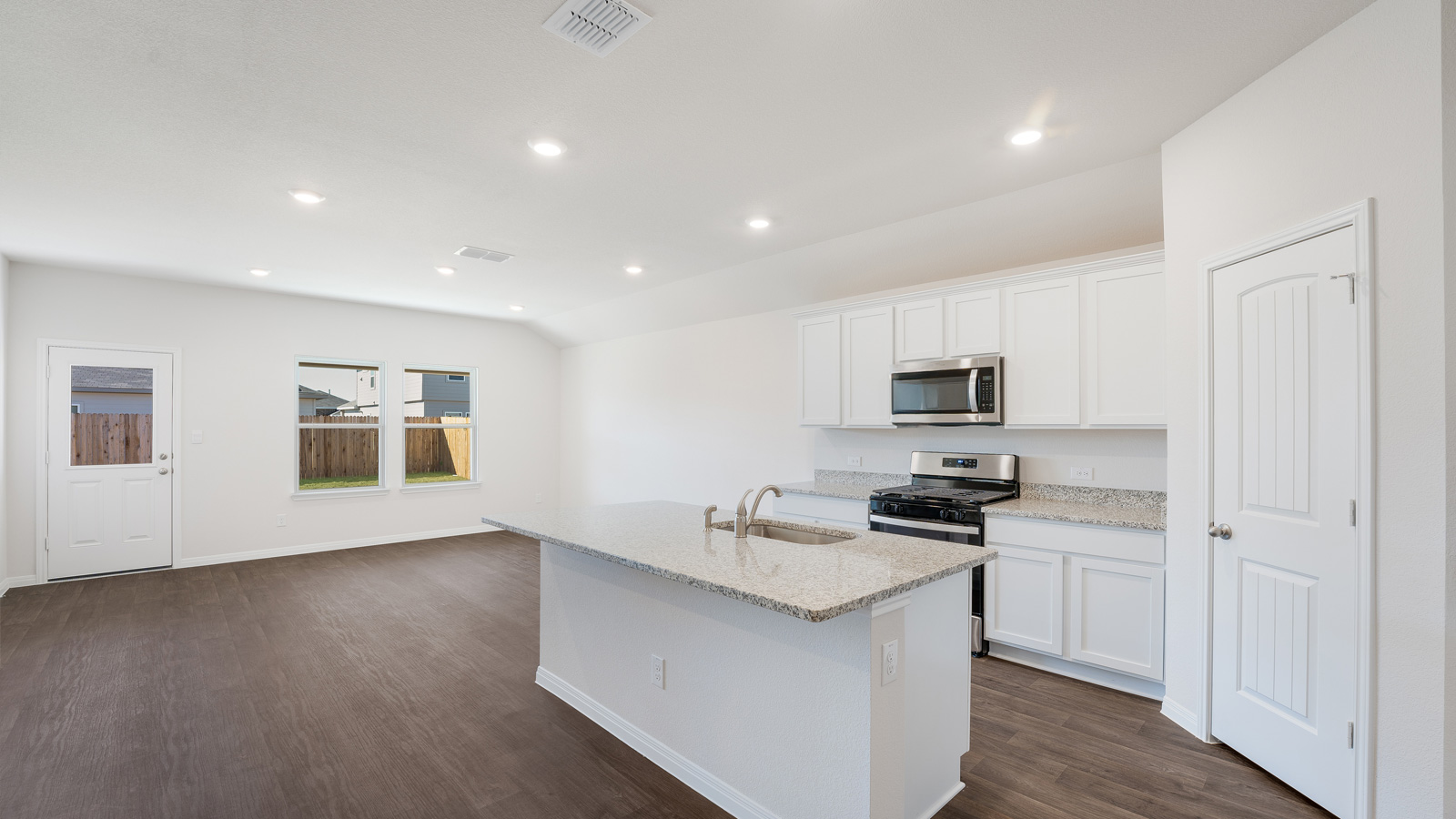 Modern kitchen with granite countertops and stainless steel appliances.