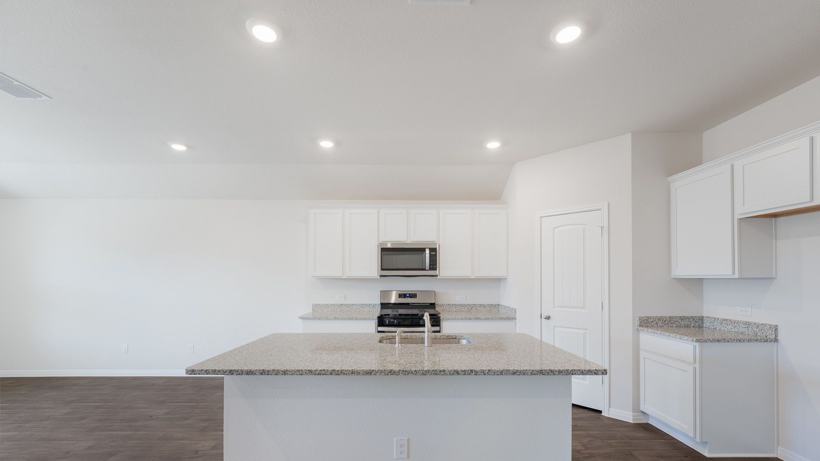 Modern kitchen with granite countertops and stainless steel appliances.