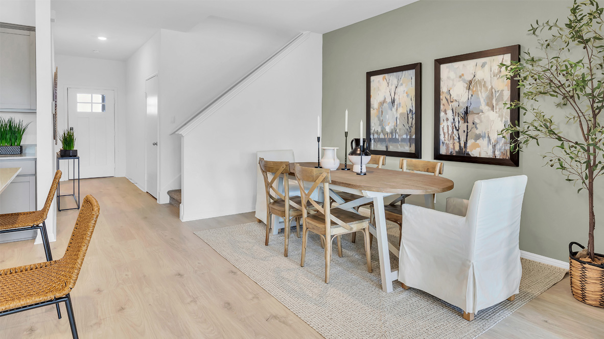 Modern dining room with a wooden table, six chairs, and abstract art. Green accent wall, light wood floor, neutral tones, and a calming atmosphere.