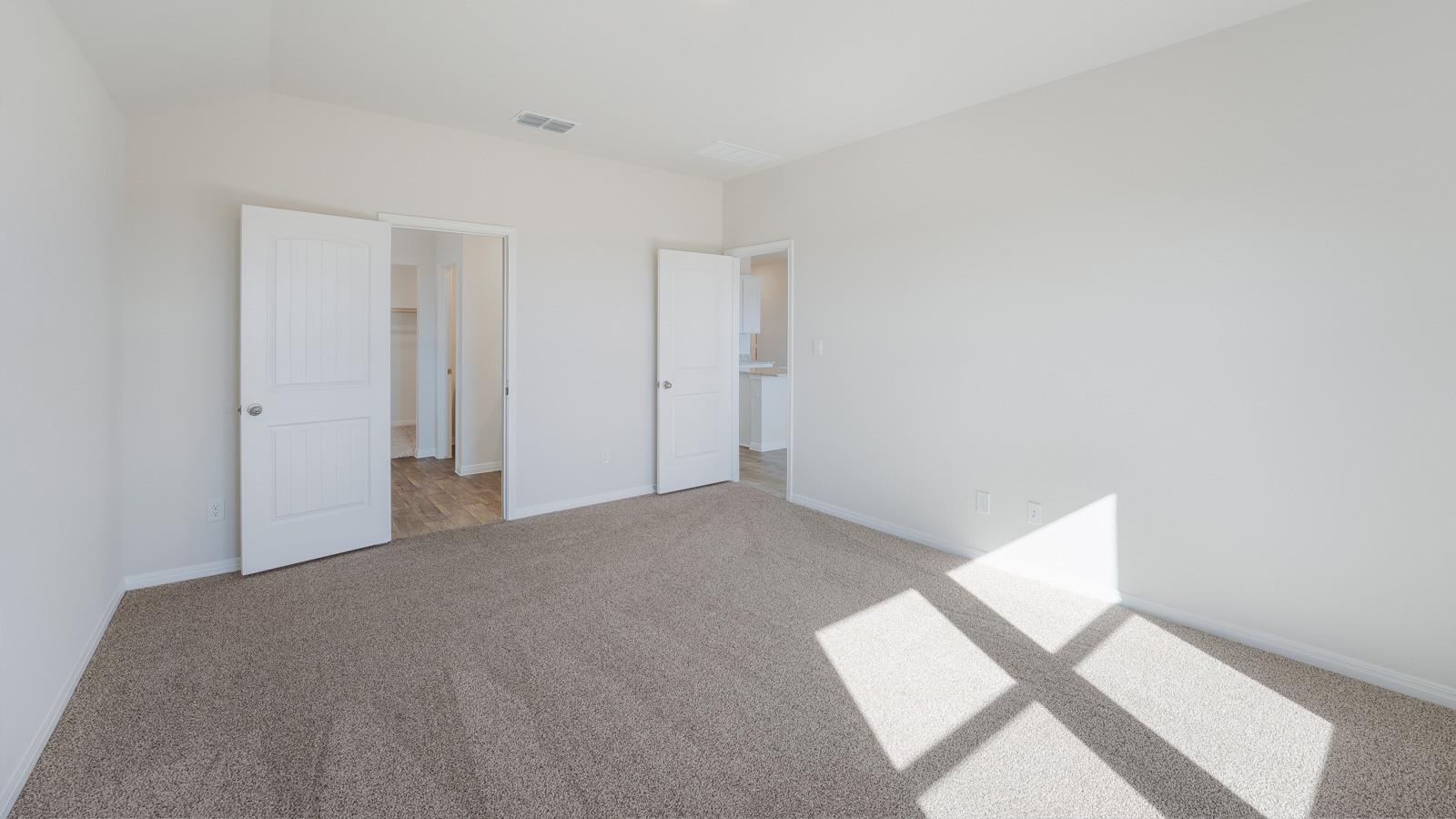 Spacious bedroom 1 with carpeted flooring.