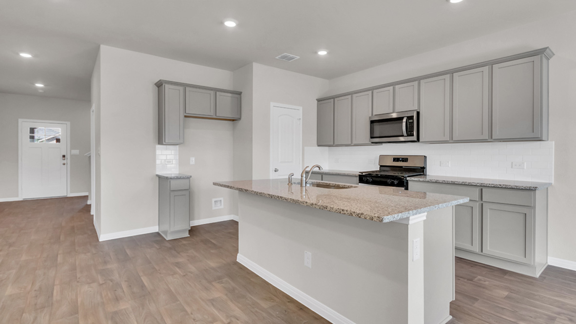 Dining room looking toward modern kitchen island, new appliance suite included at Carillon