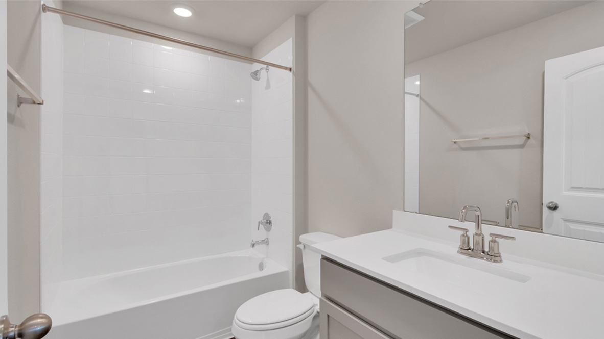 Secondary bath with built-in tub-shower combo, vanity, sink, lighting, stylish finishes in Carillon