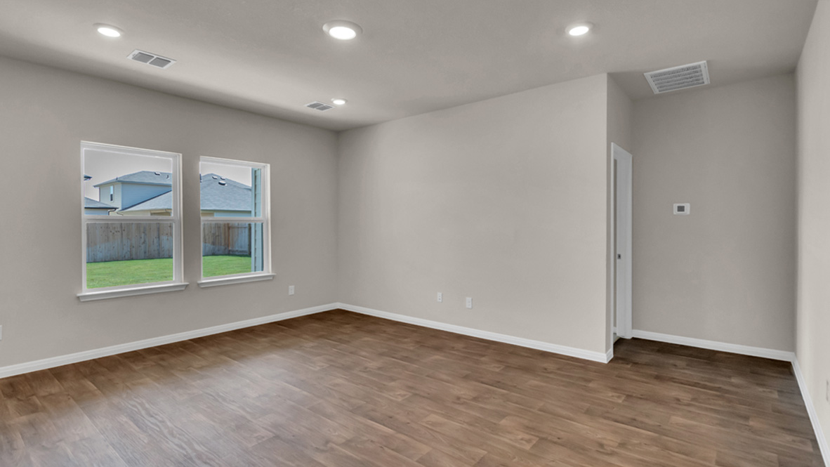 Living room in this new construction home features natural light, with fresh open concept flow to the kitchen, dining areas