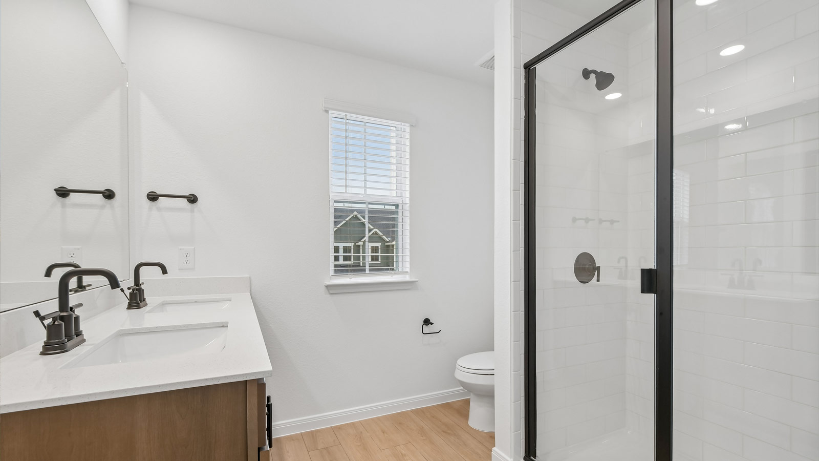 Primary bathroom with quartz dual vanity sink and walk-in shower.