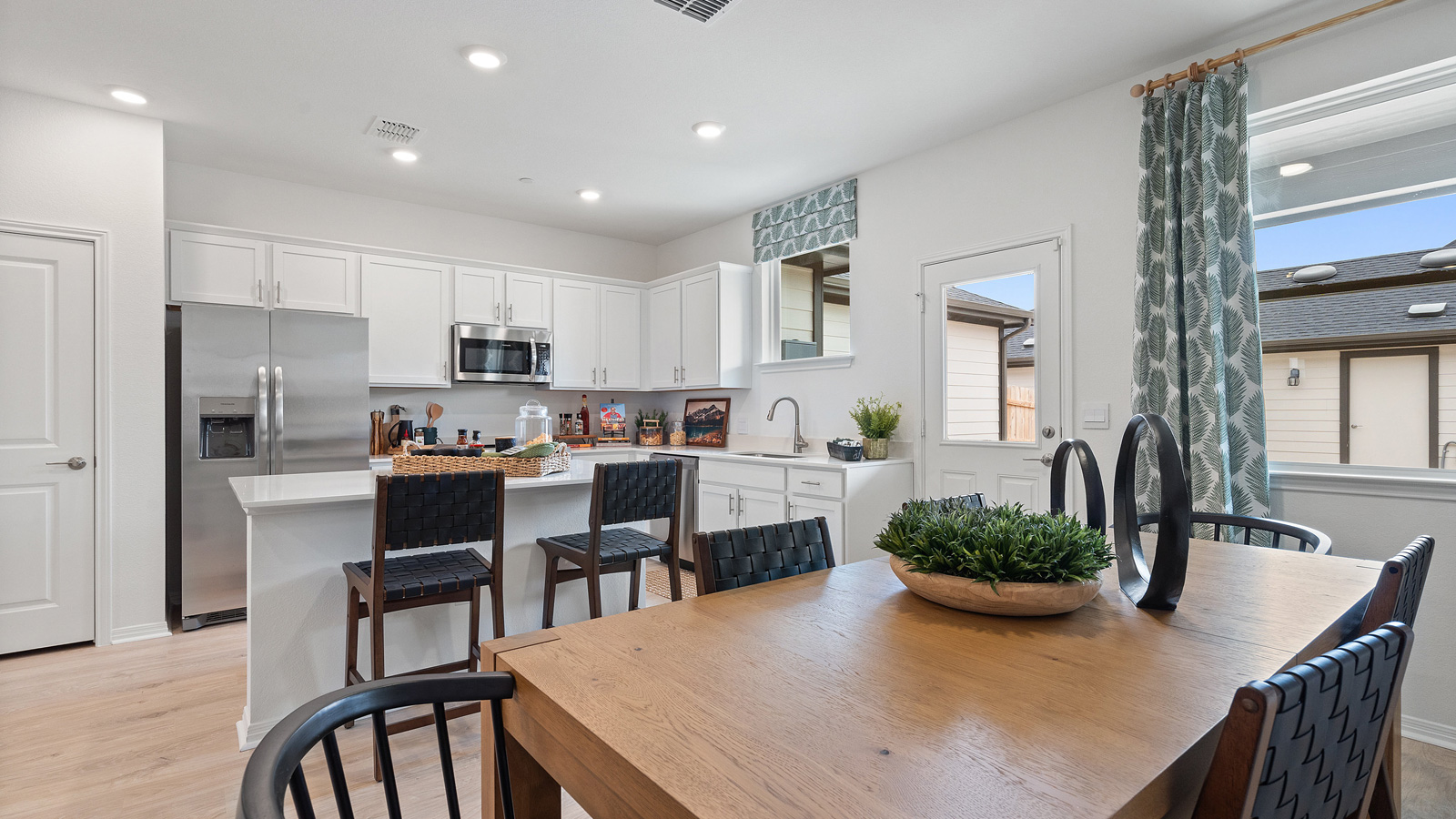 View from dining room to modern designed kitchen with pantry, new appliance suite included, stair entry