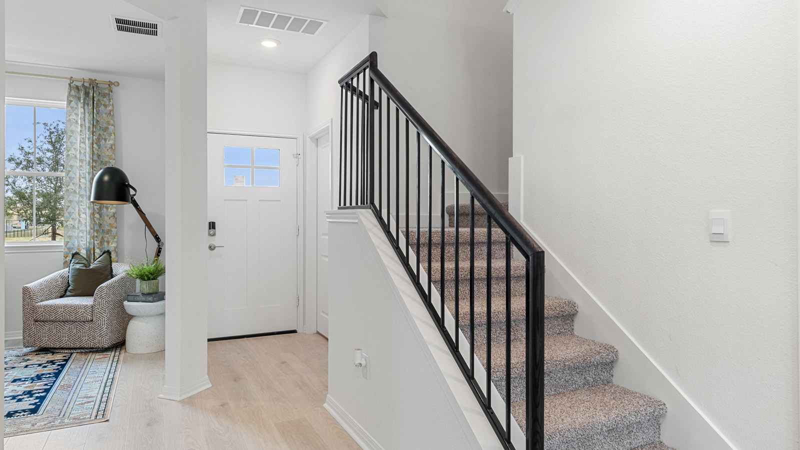 Entry hallway at front stairs in this new home features a long corridor accessing into the open concept zones