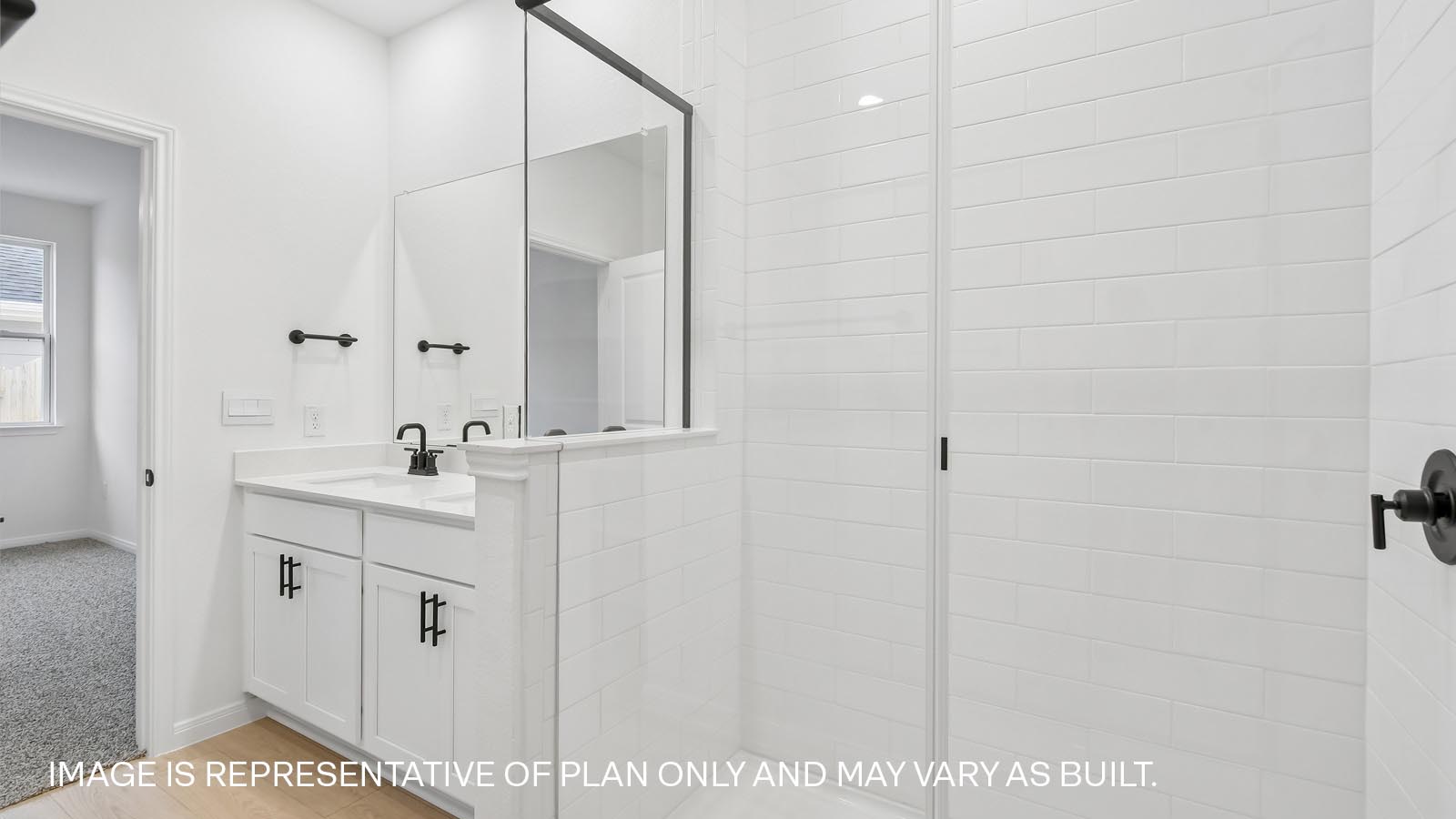 Primary bathroom with double vanity sink and walk-in shower.