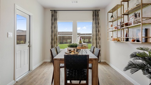 Open concept dining area with simple furnishings and a back door.