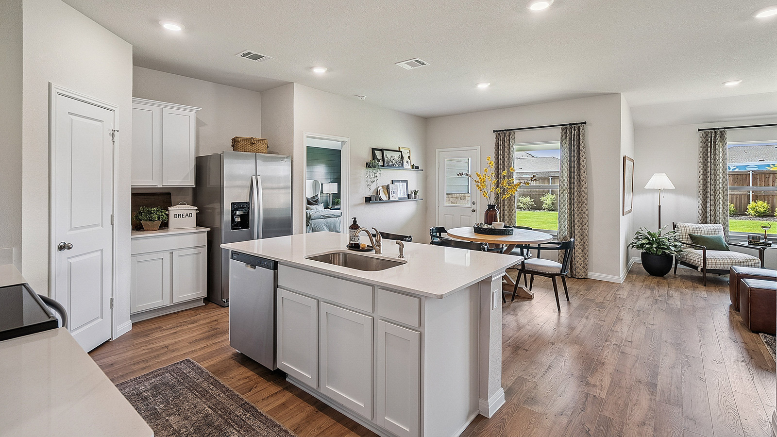 Open concept kitchen area connecting to living and dining space.