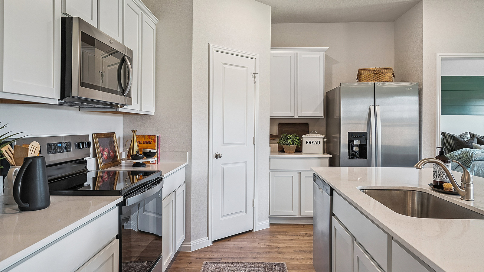 Kitchen showcasing new stainless steel appliances, cabinets, and countertops.
